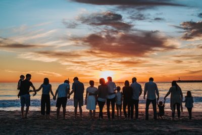 photo of a group of people lined up holding hands.