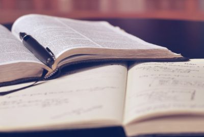 A notebook, a book, and a pen